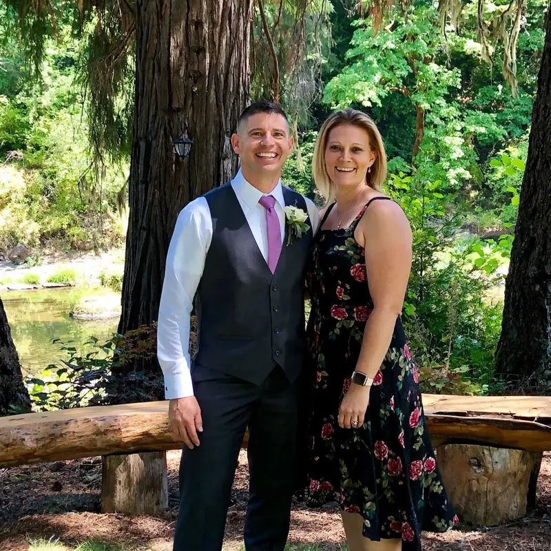 Bill Lookabaugh and his wife standing among tall Oregon forest trees